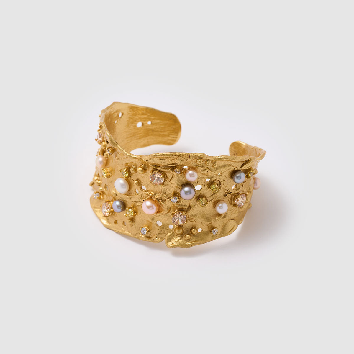Nature's Mosaic, Opulent bronze bracelet featuring layered designs with sparkling zircon stones and luxurious natural sweet water pearls, offering depth and richness to your style.
Available in gold and black finishes.