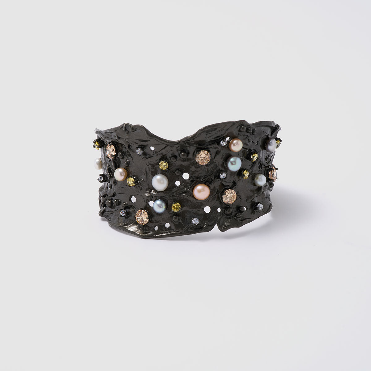 Nature's Mosaic, Opulent bronze bracelet featuring layered designs with sparkling zircon stones and luxurious natural sweet water pearls, offering depth and richness to your style.
Available in gold and black finishes.