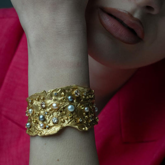 Nature's Mosaic, Opulent bronze bracelet featuring layered designs with sparkling zircon stones and luxurious natural sweet water pearls, offering depth and richness to your style.

Available in gold and black finishes.
