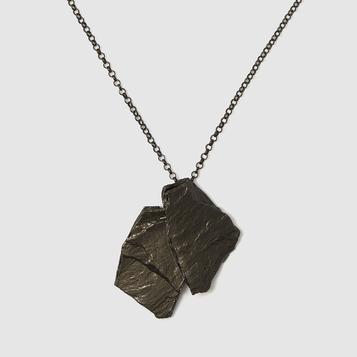 Raw Elegance, Textured pendant necklace, crafted in bronze, showcasing a rugged design that captures the essence of natural beauty.