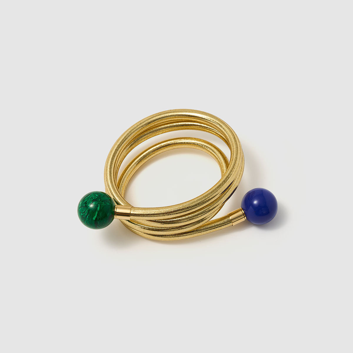 Serpentine Grace, This playful bracelet features a swirling design crafted from bronze, lurex, thermoplastic, and metal, adorned with vibrant lapis lazuli and malachite beads, offering a joyful burst of color that captures the spirit of artistic expression and individuality.