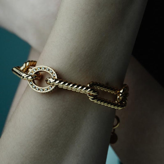 Tidal Chains, Distinctive chain bracelet crafted from brass, featuring striking geometric links and a central circle accent adorned with shimmering zircon stones.