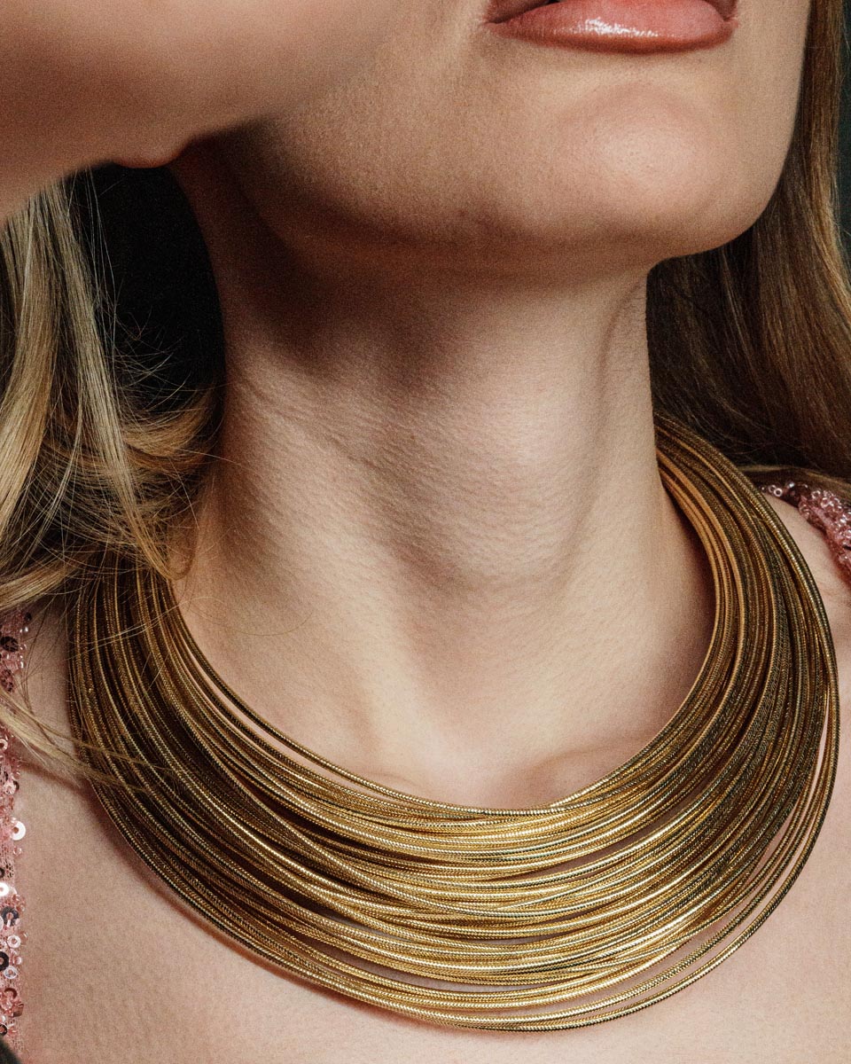 Imperial Strands, A striking silver multi-layered necklace crafted from a blend of bronze, lurex, metal and thermoplastic, offering a modern twist on classic elegance.
Available in gold and silver finishes.